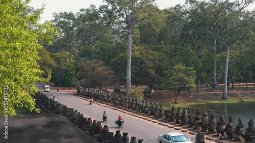 Long Shot of Traffic Crossing the Ancient Bridge Approaching Angkor Wat in Cambodia photo
