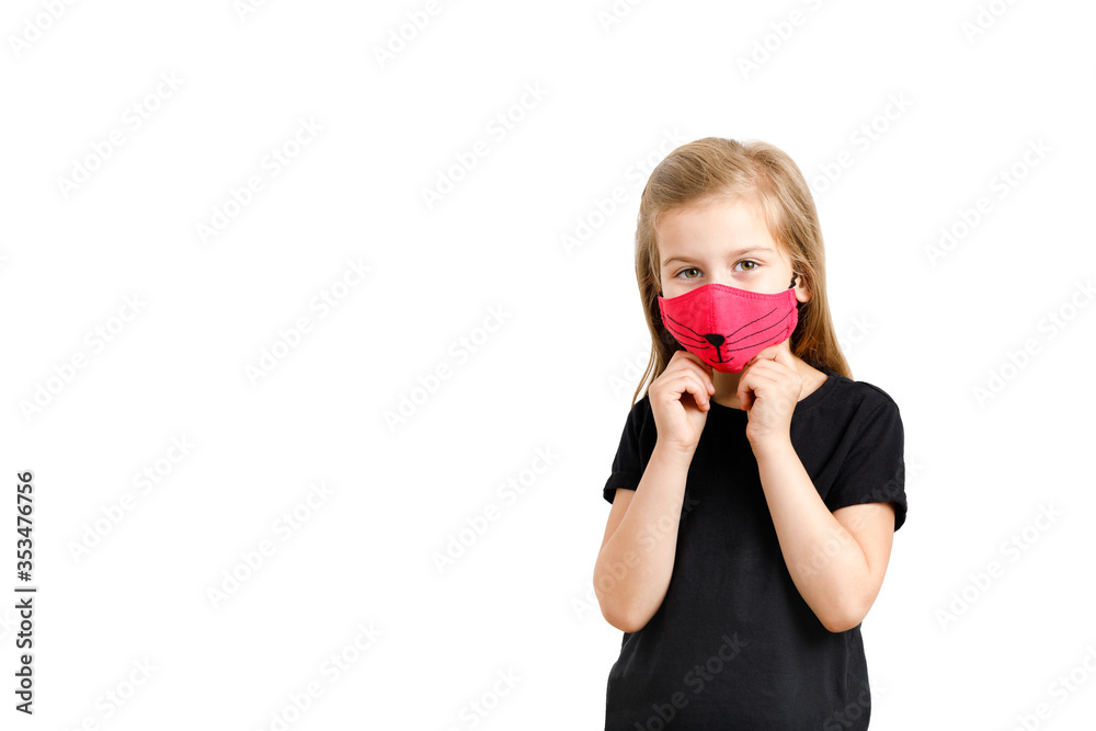 A little european girl holds a red medical mask to protect her from the virus. White background, Copy space. A little european girl holds a red medical mask to protect her from the virus. White background, Copy space.