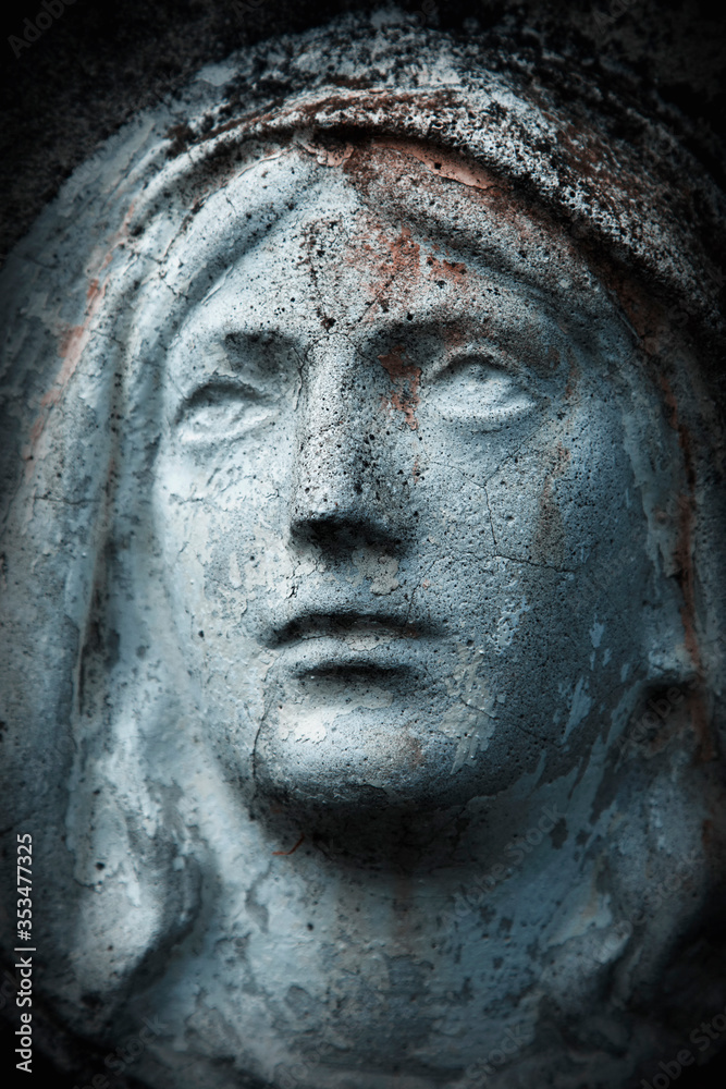 Close up ancient statue with cracks: Virgin Mary.