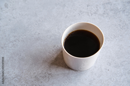 Cup of black coffee in a handmade white ceramics mug, white marble background