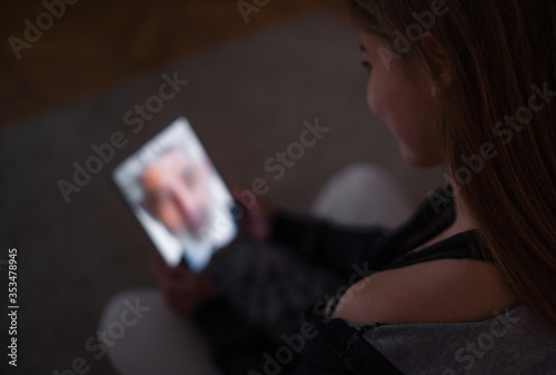 Unrecognizable young girl with laptop at night smiling, online dating concept.