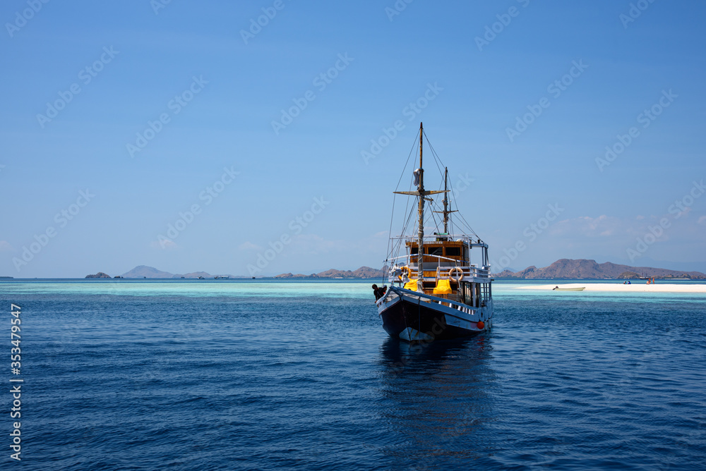 Boat anchored near Taka Makassar Island, small sandbar within Komodo National Park, East Nusa Tenggara, Indonesia