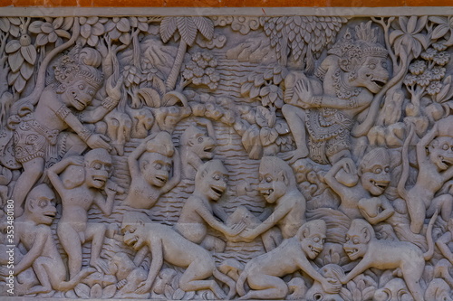 High reliefs of demons and monster fighting with monkeys in Pura Dalem Penunggekan in Bangli village, near Ubud, Island of Bali, Indonesia  photo