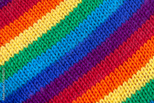 A knitted wool fabric in the colors of the rainbow. Fun background. Diagonal stripes.