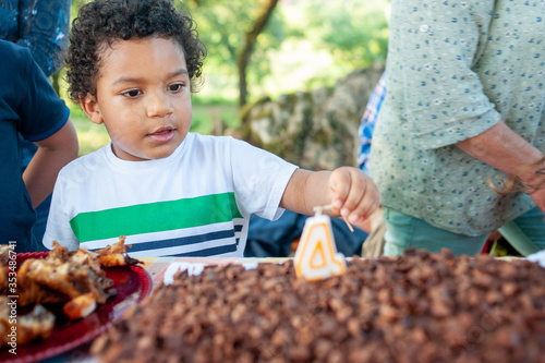 Young afro american  boy looking at his birhday cake. © Guaraciaba