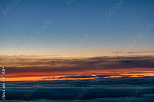 Sunset sky with colorful clouds seen through an aircraft window © Peter Vernon Morris