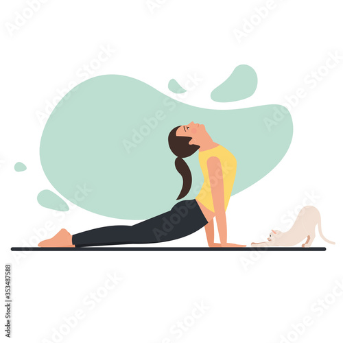 Young beautiful flexible girl doing yoga at home with pet. 