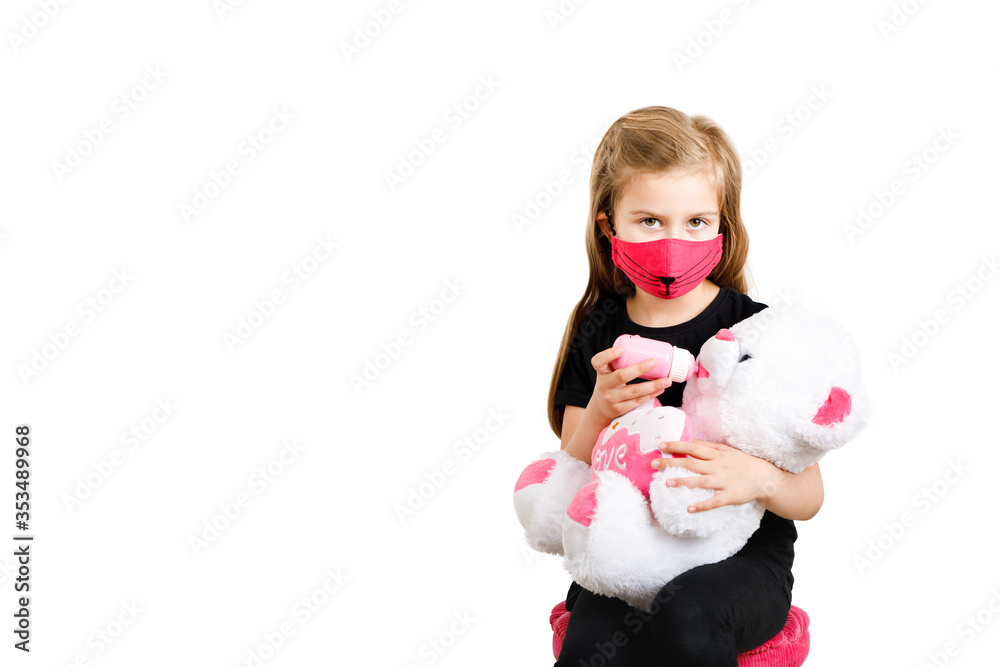 A child in a red medical mask feeds a teddy bear. Isolated on white background Copy space A child in a red medical mask feeds a teddy bear. Isolated on white background Copy space