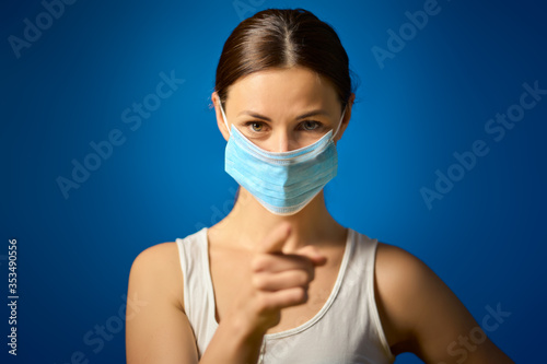 woman in white shirt shows how to wear a mask during a pandemic
