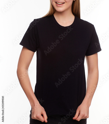 Front view - Advertising and T shirt design concept. Cropped portrait of stylish woman wearing black T-shirt standing against white studio wall with copy space for your promotional