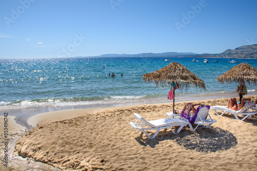 Pefkos beach with holiday-makers, sun beds and umbrellas in village of Pefkos (Rhodes, Greece) photo