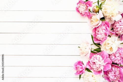 Beautiful pink and white peonies on white wooden background. Birthday, Valentines Day, Happy Mother's day or Women's day concept. Top view, copy space.