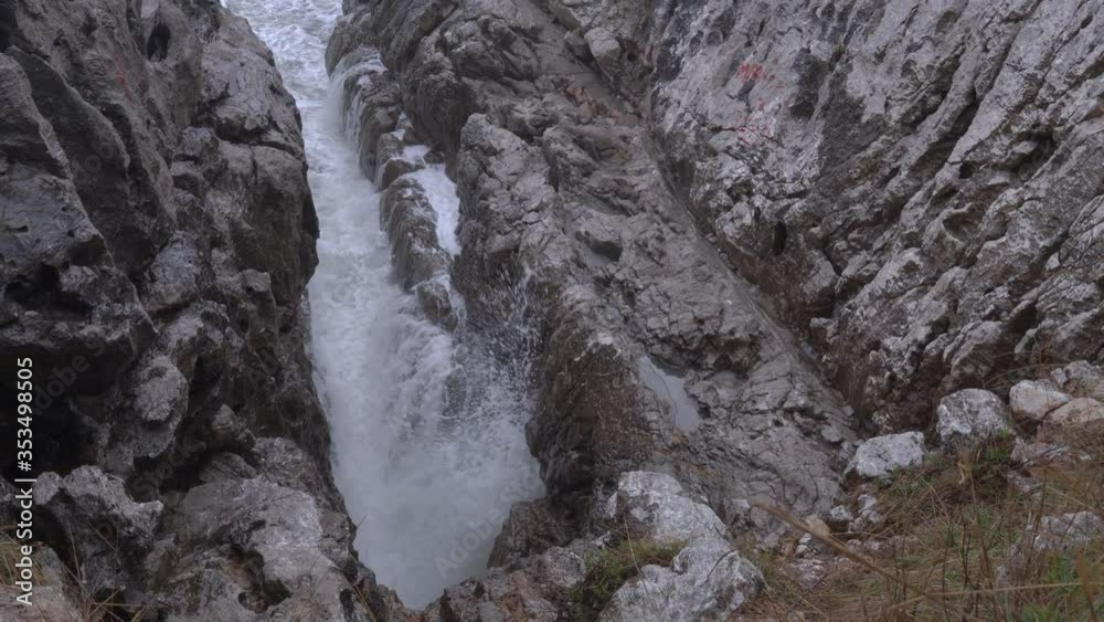 Narrow canyon between rock cliffs where stormy waves are beaten and smashed up. Great power of severe nature. Gray water color in bad weather, Mediterranean sea at Montenegro, East Europe. Narrow canyon between rock cliffs where stormy waves are beaten and smashed up. Great power of severe nature. Gray water color in bad weather, Mediterranean sea at Montenegro, East Europe.