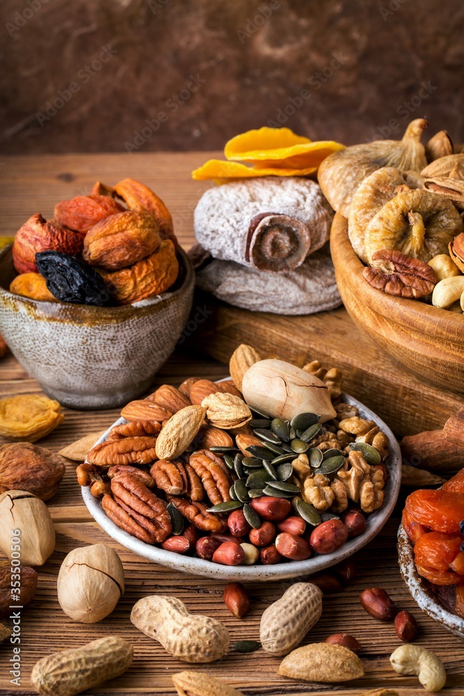 Composition from mix of nuts and dried fruits. Brown background, vertical format Composition from mix of nuts and dried fruits. Brown background, vertical format