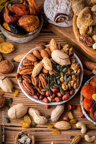 Composition from mix of nuts and dried fruits. Brown background, vertical format