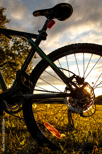 Bicycle wheel in the field at sunset. Close-up of a hydraulic brake disc photo