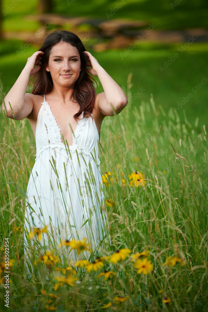 Stunning young Caucasian woman poses in white dressing field - summer fashion Stunning young Caucasian woman poses in white dressing field - summer fashion
