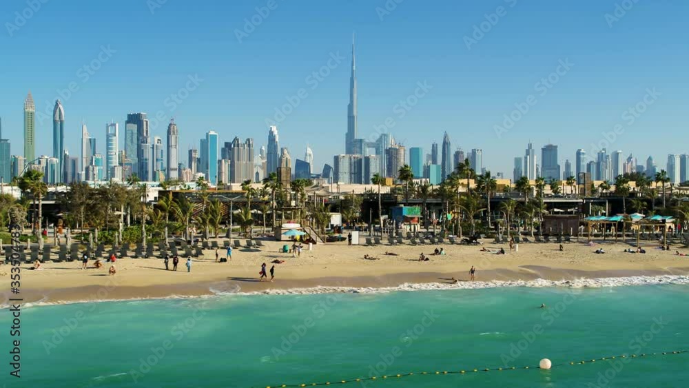 Aerial view of a luxury beach with Dubai skyscrapers at the background, U.A.E.