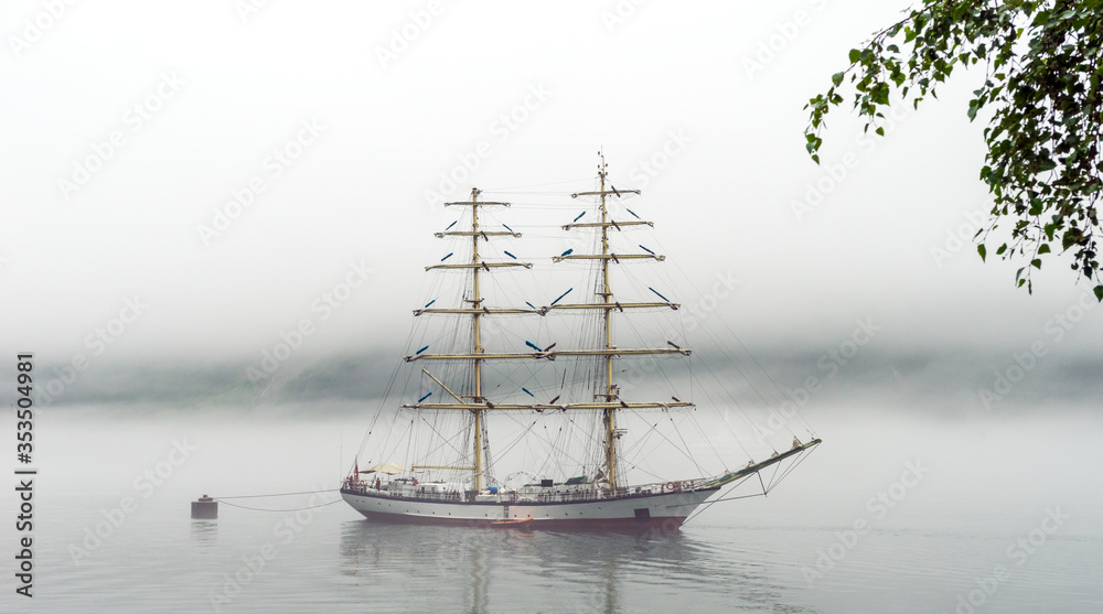 Fototapeta premium Big and tall sail ship in Geiranger fjord in Norway during misty day.