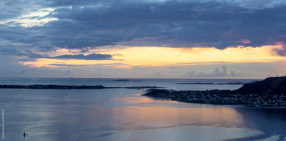 Fototapeta premium Sunset with rain clouds and colorful scenery over fjords and islands in Aalesund Norway.