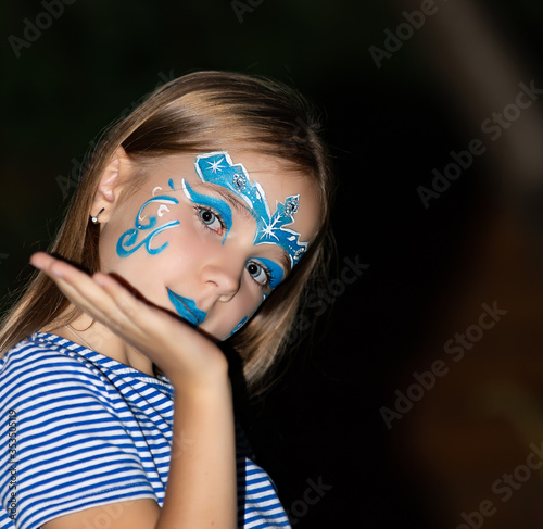 Girl with blue eyes and face painting, aqua mask