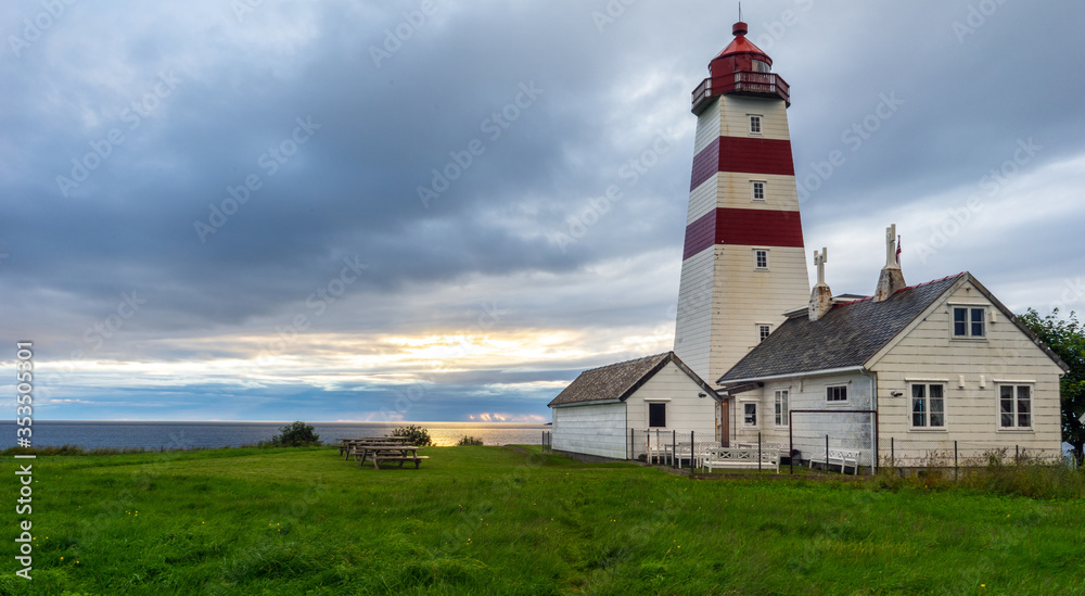 Alnes lighthouse in Godoy, Aalesund, Norway during sunset and blue hour.