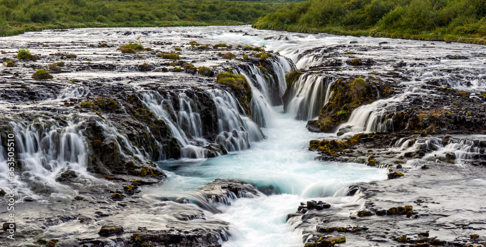 Closeup of tiny little cascades and turquoise waterfall called Bruarfoss in the Icelandic countryside.