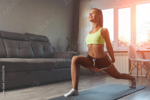 Young caucasian woman Stretching on yoga mat at home. Workout at home concept.