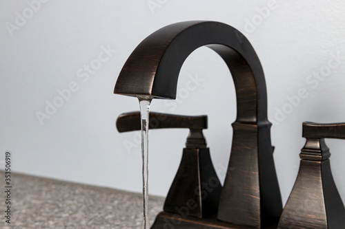 Bathroom sink faucet with water flowing. Concept of DIY home repair, plumbing maintenance, clean water, water conservation