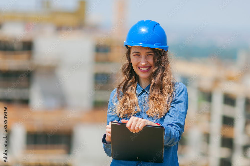 young woman working in construction site and holding clipboard with documents young woman working in construction site and holding clipboard with documents