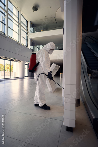 cleaning the surfaces of a building using special protective clothes and disinfection equipment