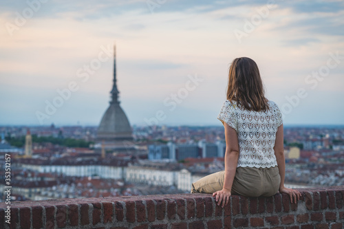brunette woman enjoy panorama of Turin. Amazing scenic view on Mole Antonelliana. Girl explore Piemonte, Italy. Town and mountain. Cityscape, old historic architecture. Travel, adventure, lifestyle
