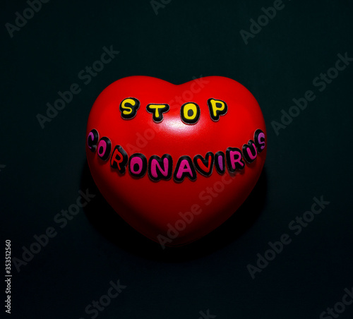 Red heart with the words stop coronavirus, on a black background.