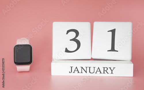 Modern Watch with cube calendar and date 31 january on pink background. Concept winter time vacation.