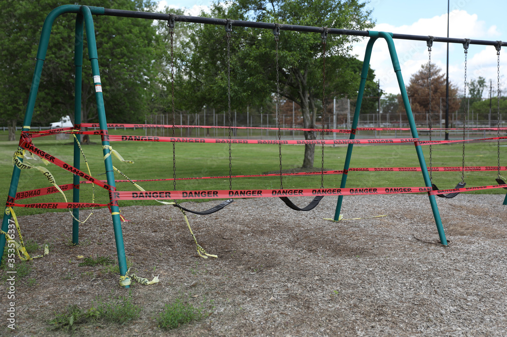 Danger tape is wrapped around playground equipment, indicating the park is closed due to Covid-19 concerns. Danger tape is wrapped around playground equipment, indicating the park is closed due to Covid-19 concerns.