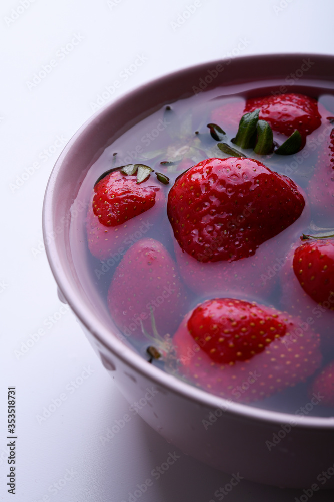Fresh strawberries in a bowl with water