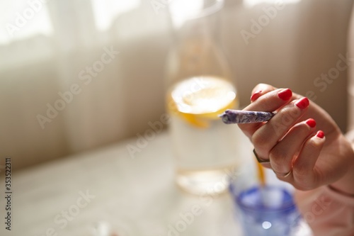 Stylish Woman Smoking a Joint at Home photo