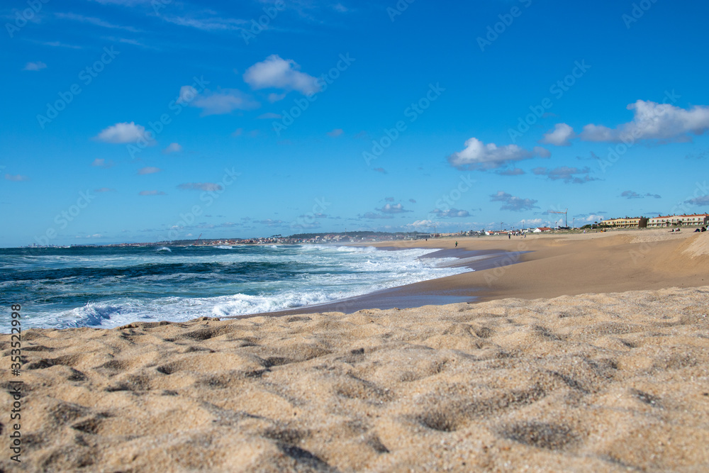 Panoramic shot over the beach with rough sea and blue sky, spring time on nature. Cost line of Atlantic ocean from north of Portugal.