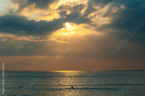 A surfer in the sea waits for waves during sunrise at the Recreio Beach, located in the west of Rio de Janeiro, Brazil.