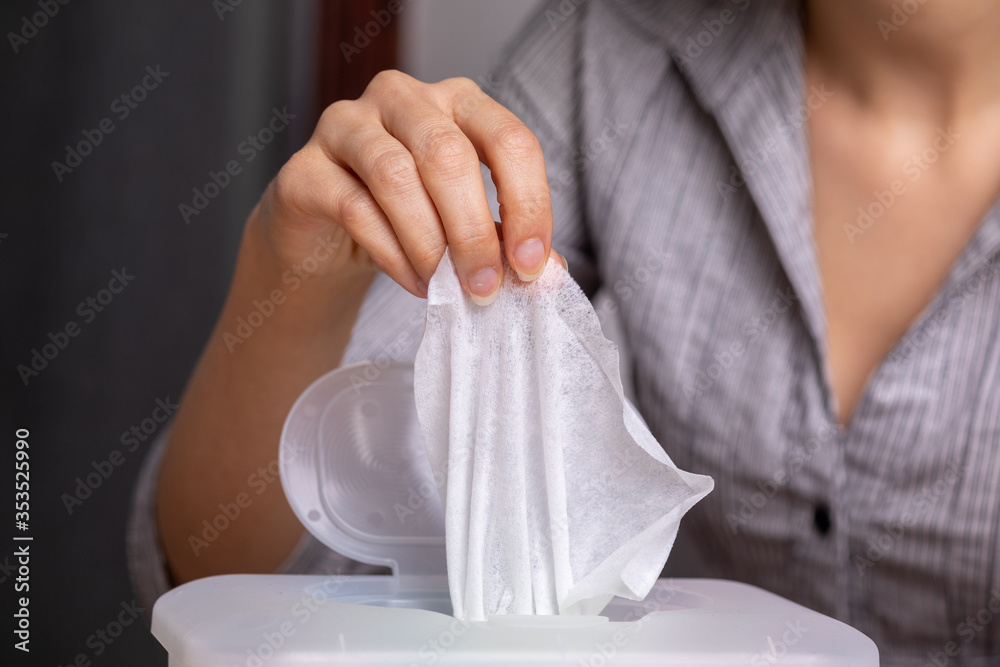 Wet wipes are universal an practical: woman take one wipe from big Wet wipes are universal an practical: woman take one wipe from big