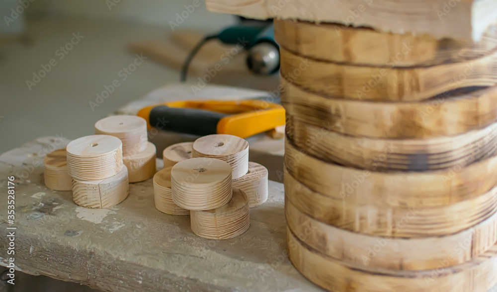 wooden blanks, wheels, circles lie on the carpenter's workbench against the background of tools wooden blanks, wheels, circles lie on the carpenter's workbench against the background of tools
