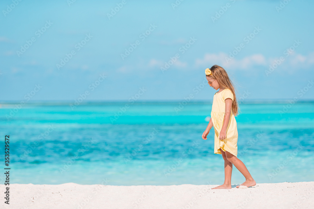 Adorable little girl have fun at tropical beach during vacation Adorable little girl have fun at tropical beach during vacation