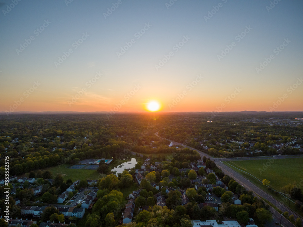 Aerial of a sunset over Rockville and Darnestown in Montgomery County, Maryland. Sugarloaf mountain is on the right horizon.