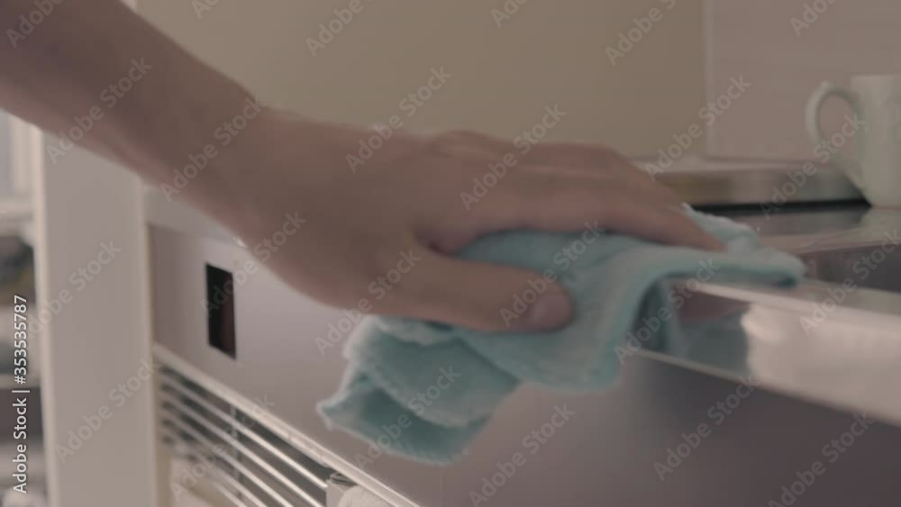 Person cleans surface with 70 percent alcohol based sanitizer to kill corona virus. Covid-19 is a pandemic that has changed peoples cleaning habits to help prevent further spread of deadly virus.