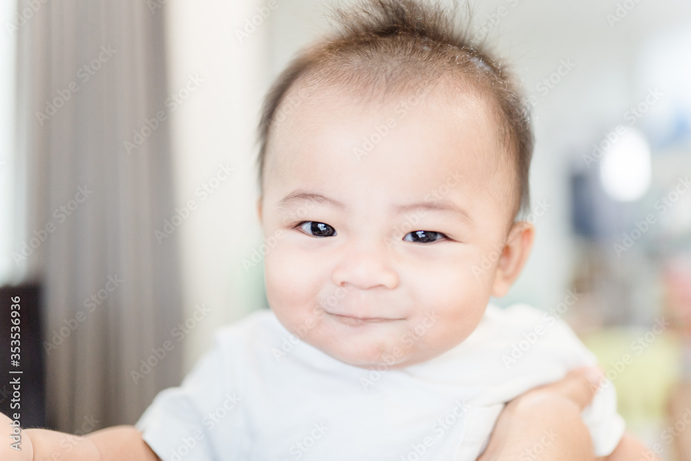 smiling cute baby boy stay at home.Asian child infant 6 month laughing looking at camera wearing white t-shirt.Infant, People, Healthcare, Pediatric, Healthy lifestyle.Active kid with smile good mood.