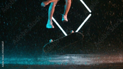 Advanced skateboard hardflip trick in wet rain studio effect, caucasian man photo