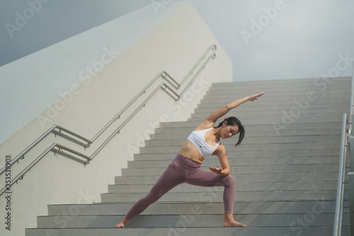 Street Yoga - Asian Chinese Woman doing yoga in public spaces