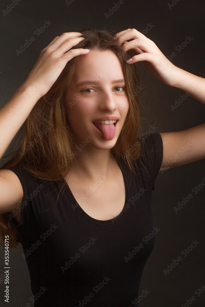 Studio portrait of a young girl with long hair on black background Studio portrait of a young girl with long hair on black background
