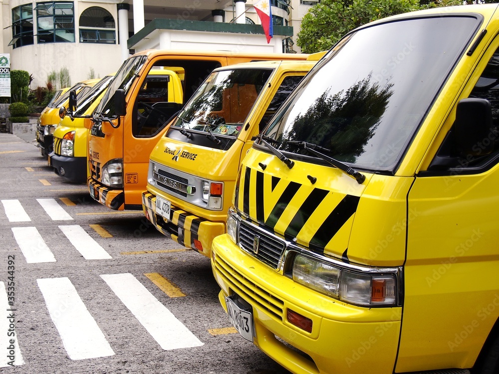 School service vehicles parked inside a school parking lot Stock Photo