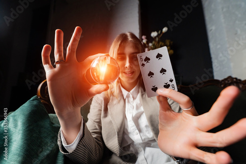 Woman in business suit holding crystal ball and six spade